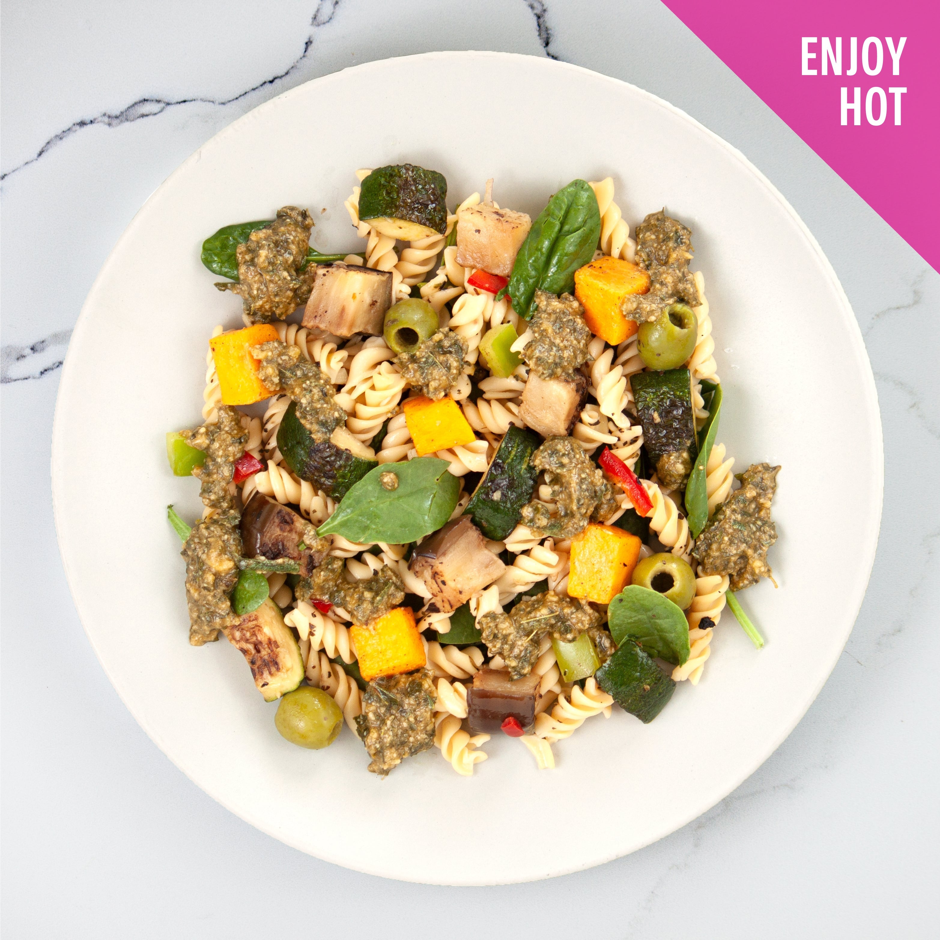 Hot pesto pasta with vegetables and olives